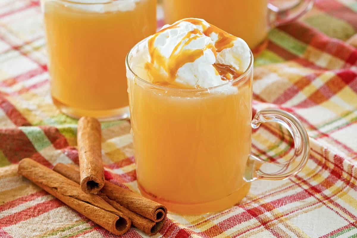 Hot spiced apple caramel drink in a glass mug.