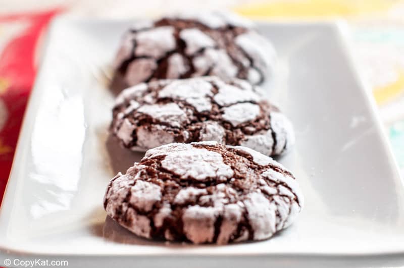 chocolate crinkle cookies on a rectangular white plate.