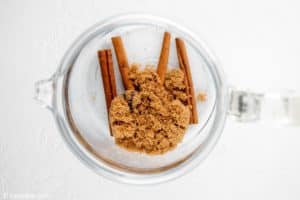 cinnamon sticks and brown sugar in a coffee pot.