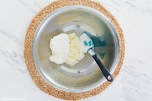 clam dip ingredients and a spatula in a bowl.