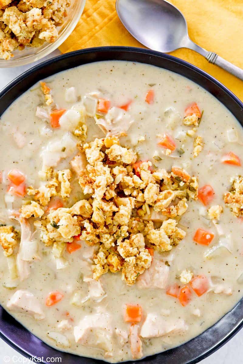 overhead view of a bowl of creamy turkey soup topped with stuffing.