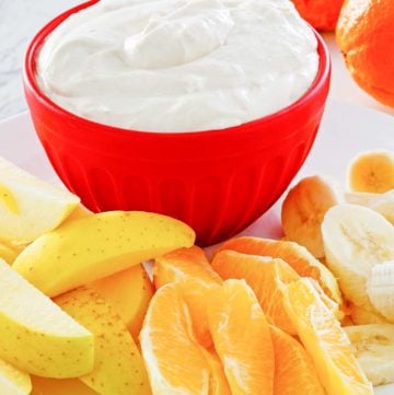 fruit dip in a bowl and various fresh fruit next to it.