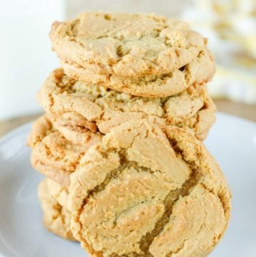 homemade gingersnap cookies stacked on a plate.