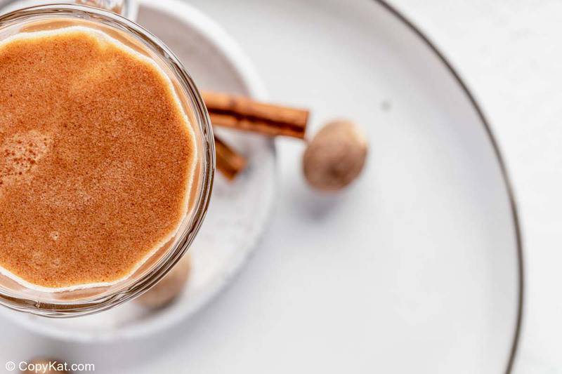 overhead view of hot buttered rum in a glass mug.