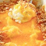 mashed potato casserole topped with cheese and fried onions.