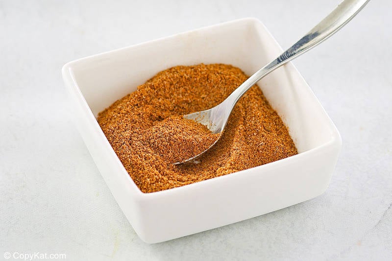 homemade old bay seasoning and a spoon in a small square bowl.