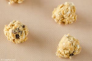 oatmeal raisin cookie dough balls on a baking sheet.