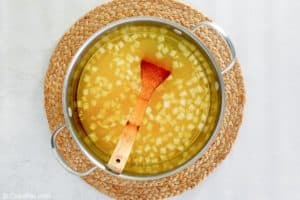 chicken stock and onions in a pot.