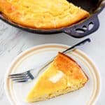 sour cream cornbread in a skillet and a slice on a plate.