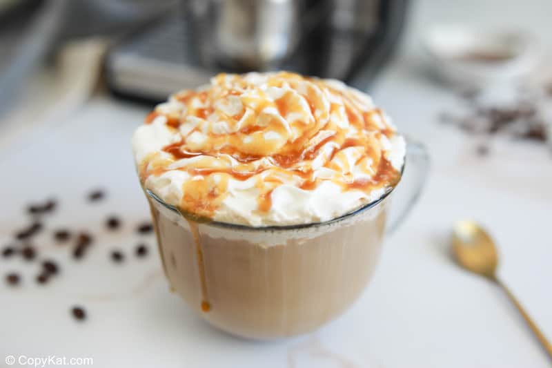 homemade Starbucks caramel latte topped with whipped cream and caramel drizzle.