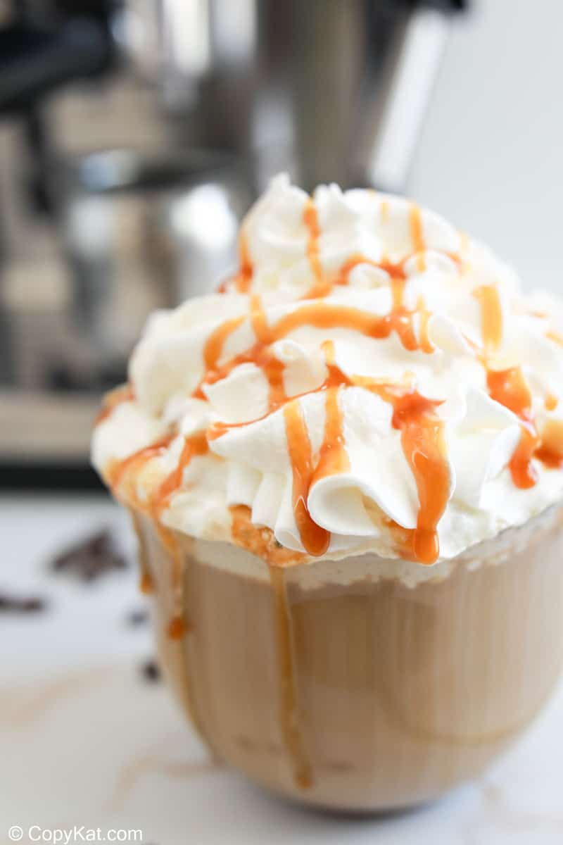 homemade Starbucks caramel latte with whipped cream and caramel drizzle on top.