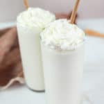 two homemade Starbucks vanilla bean frappuccino drinks topped with whipped cream.