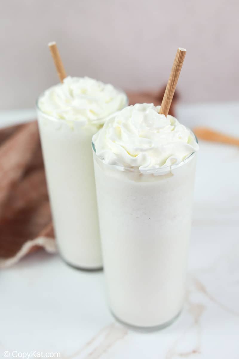 two homemade Starbucks vanilla bean frappuccino drinks topped with whipped cream.