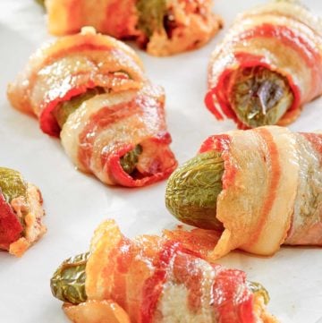 bacon wrapped jalapeno poppers on parchment paper.