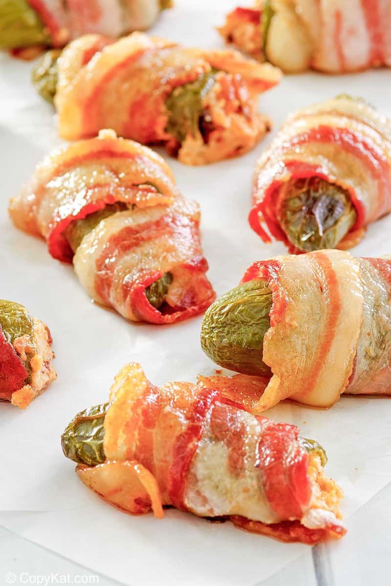 bacon wrapped jalapeno poppers on parchment paper.