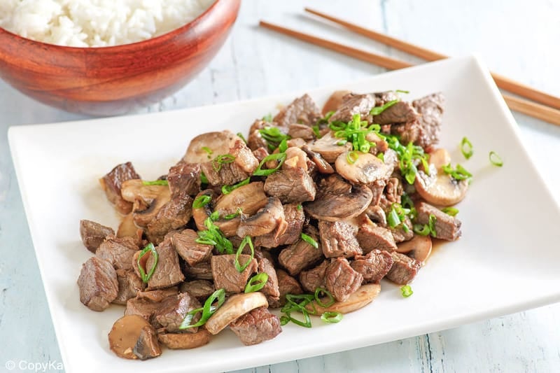 homemade Benihana steak and mushrooms on a platter and a bowl of rice.