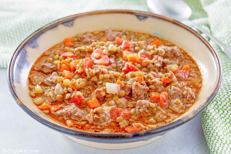 bowl of homemade Carrabba's sausage lentil crockery   and a spoon.