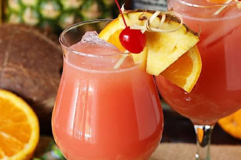 Caribbean rum punch garnished with a cherry, pineapple, and orange.