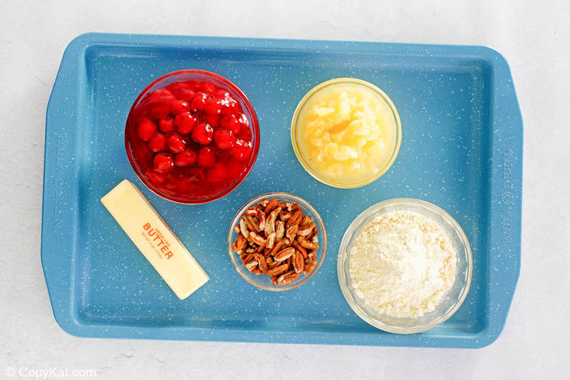 cherry pineapple dump cake ingredients on a tray.