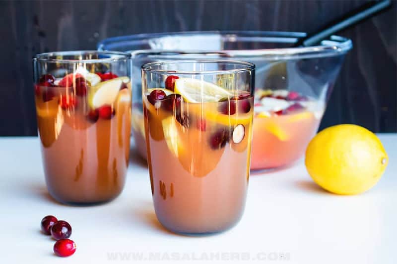 Christmas punch in two glasses and a punch bowl.