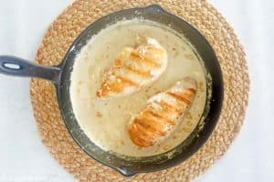 chicken breasts and cream cheese sauce in a skillet.