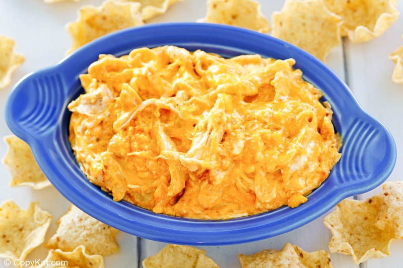 Frank's Buffalo chicken dip and tortilla chips scattered around it.