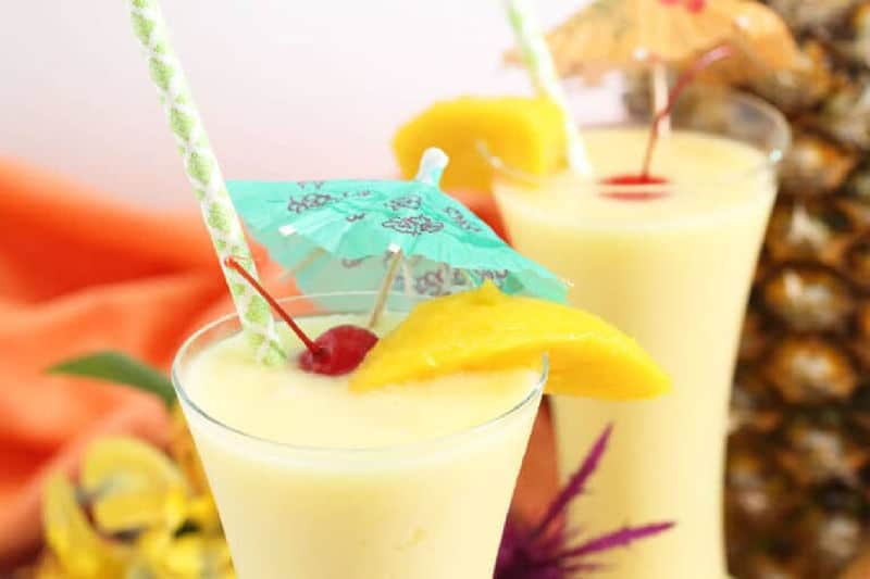 mango colada garnished with a slice of fresh mango.