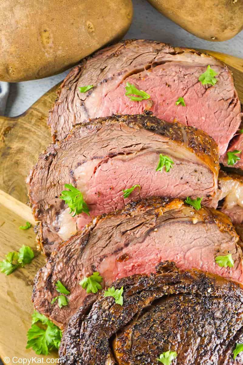 slices of prime rib ribeye roast and two potatoes.