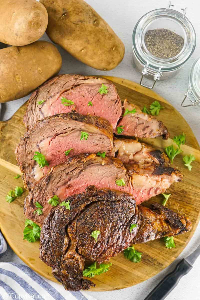 overhead view of prime rib ribeye roast slices and potatoes.