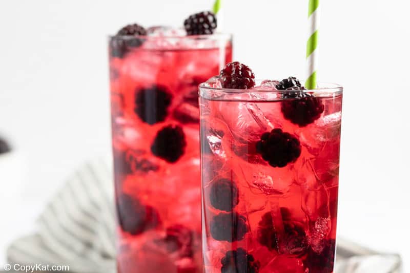 homemade Starbucks very berry hibiscus refresher drinks on ice with blackberries.