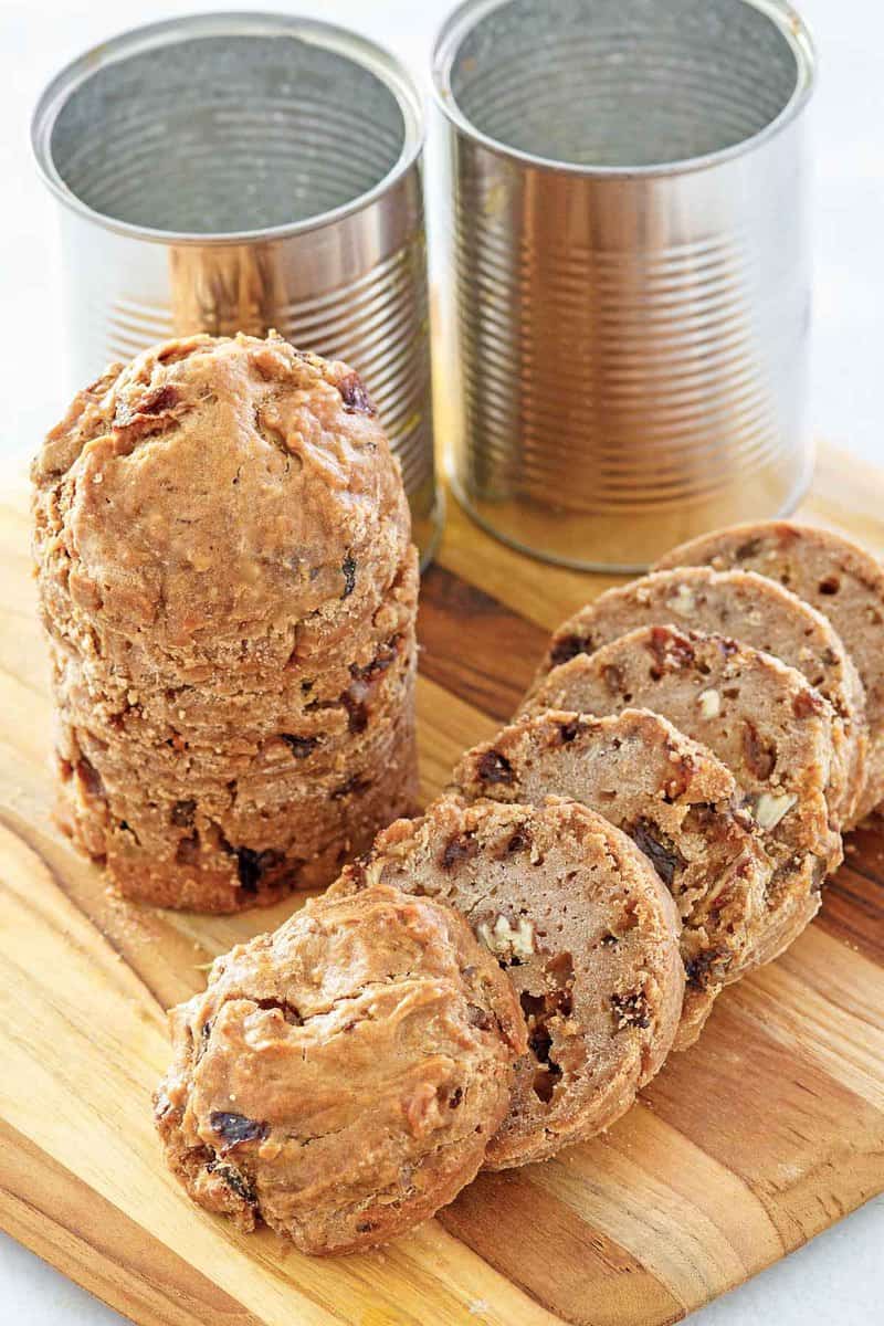 Boston brown bread loaves and cans on a cutting board.