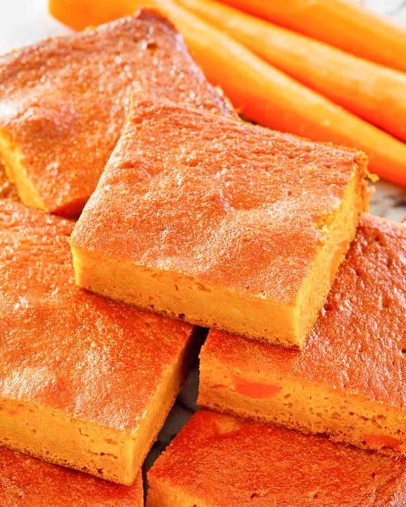 carrot pudding slices stacked and carrots.