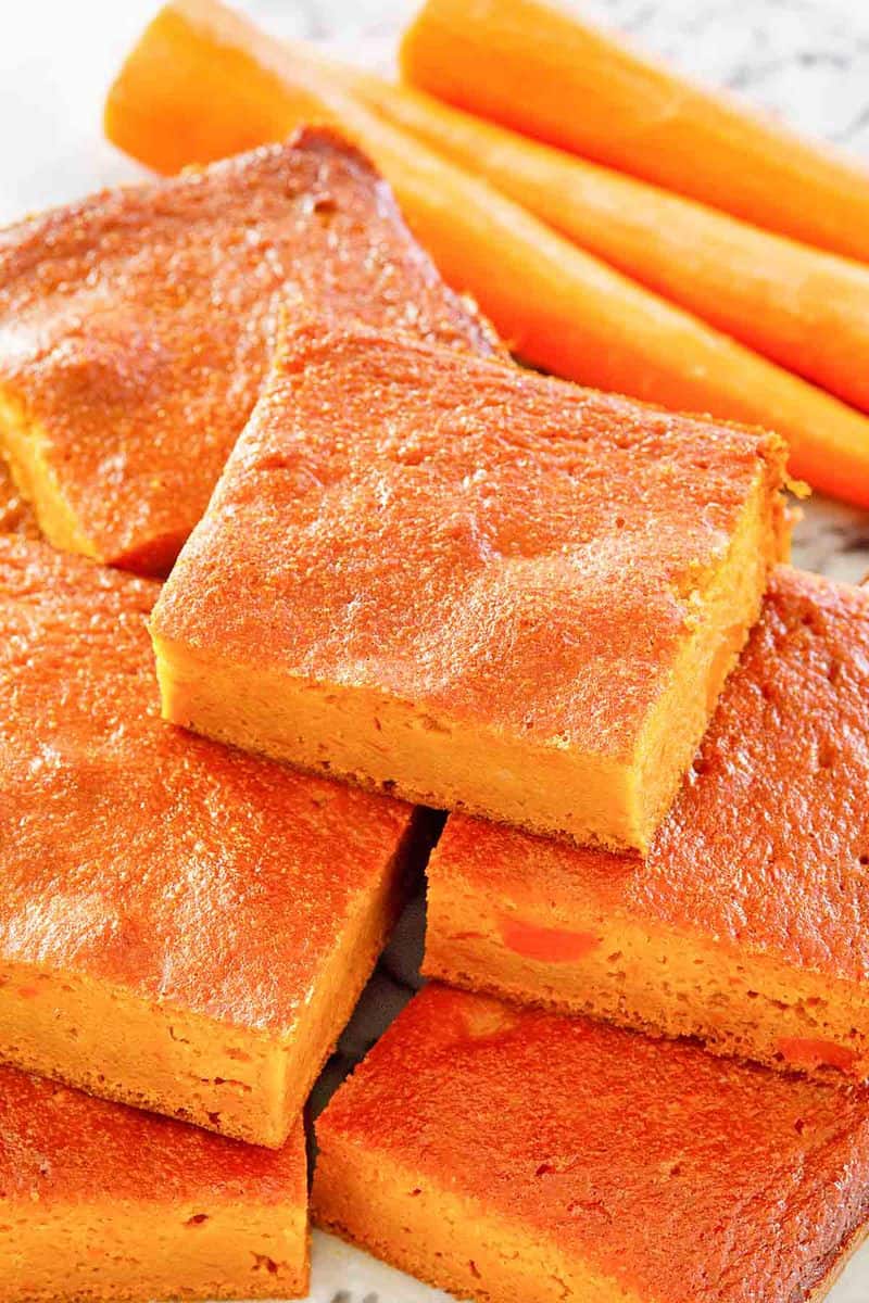 carrot pudding slices stacked and carrots.