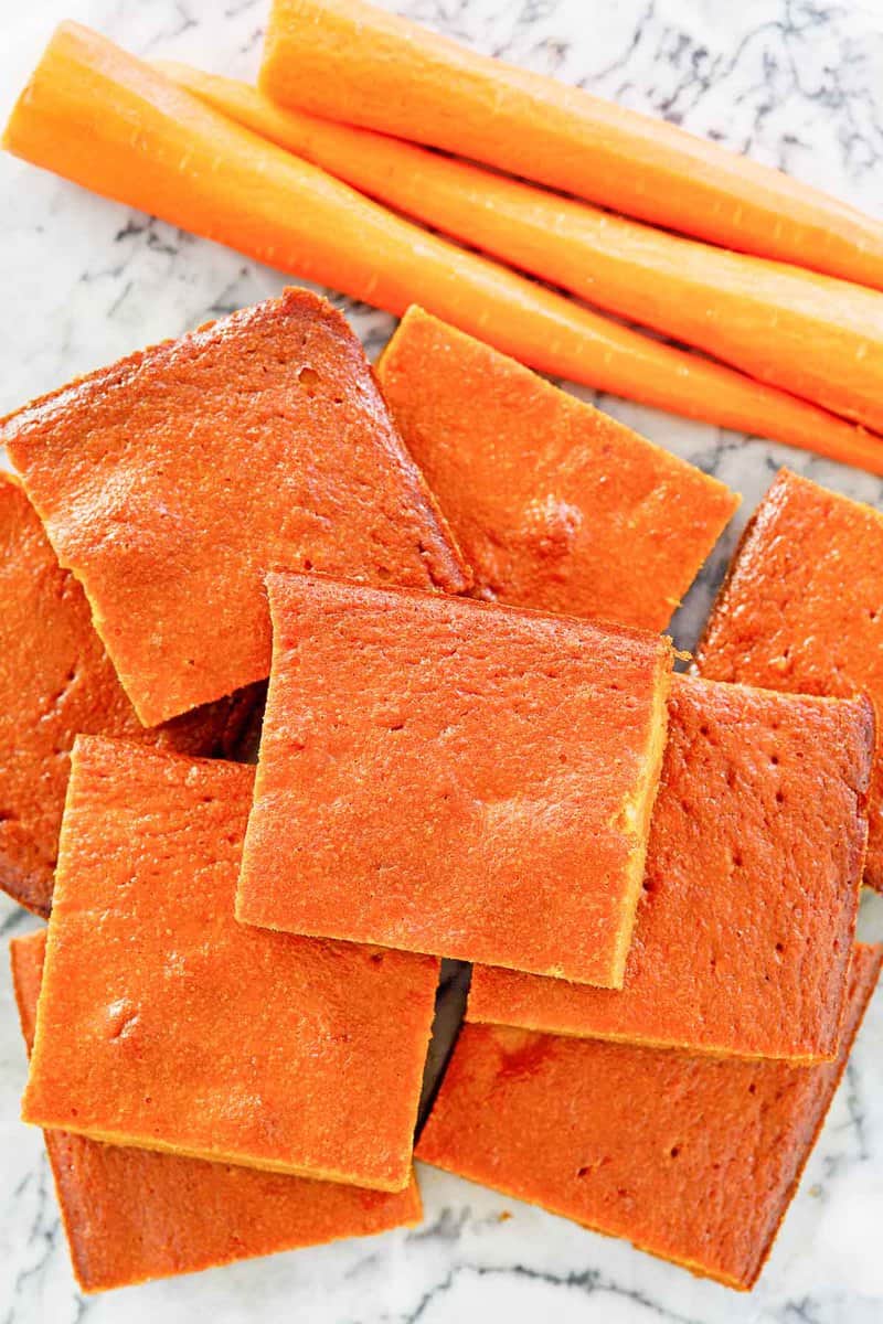 overhead view of carrot pudding slices and carrots.