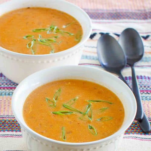 two bowls of chicken enchilada soup and two spoons.