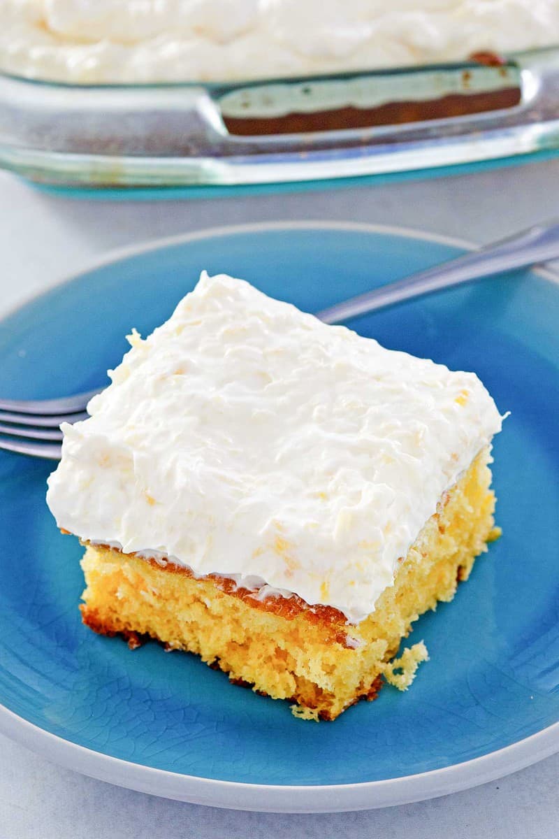 mandarin orange cake slice and a fork on a plate.