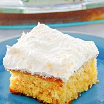 mandarin orange cake slice on a plate in front of the cake.