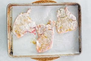 breaded mustard pork chops before baking.