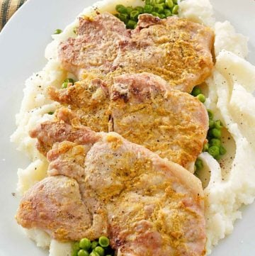 mustard pork chops over peas and mashed potatoes.