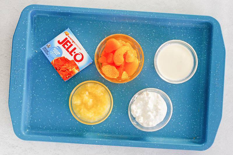 orange fluff jello salad ingredients on a tray.