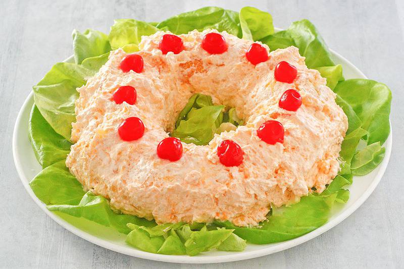 orange fluff jello salad on a lettuce-lined platter.