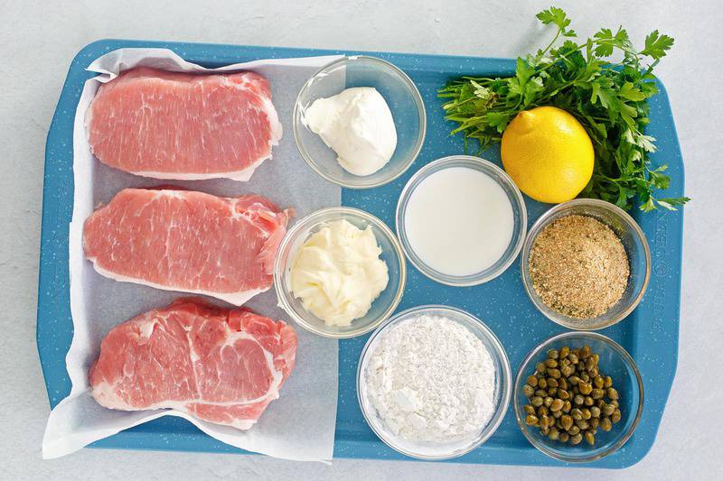 pork milanese with lemon caper sauce ingredients on a tray.