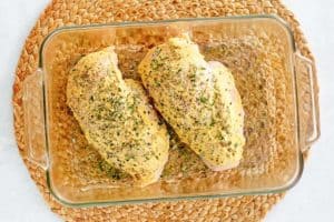 chicken breasts with rosemary mustard in a baking dish.