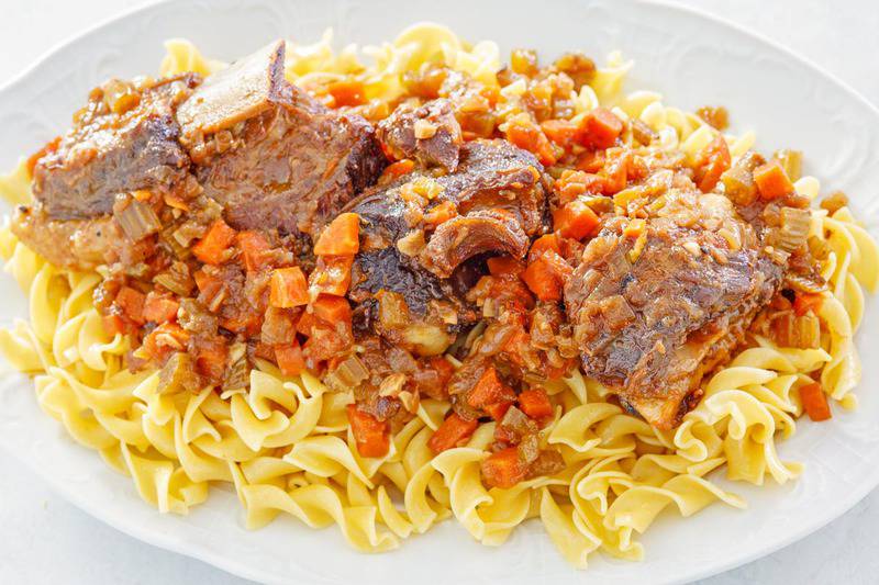 braised short ribs over noodles on a platter.