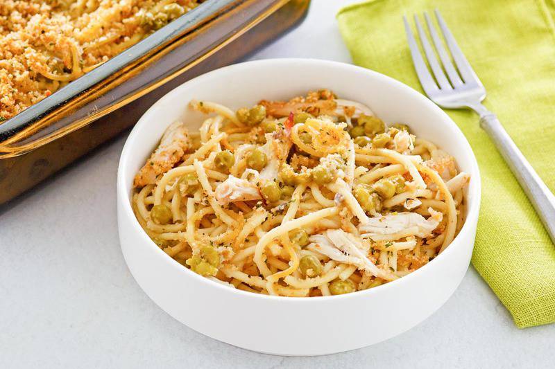 chicken tetrazzini in a bowl and a fork on a napkin.