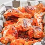 grilled buffalo wings in a parchment paper lined basket.