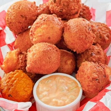 homemade hush puppies and remoulade sauce in a basket.