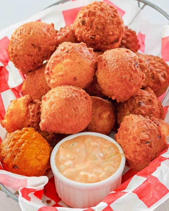 homemade hush puppies and remoulade sauce in a basket.