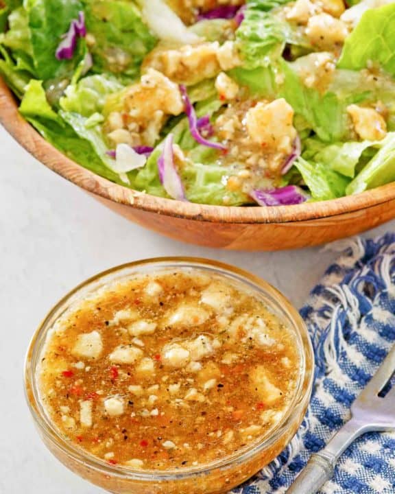 homemade Outback blue cheese vinaigrette dressing in a small bowl and on a salad.