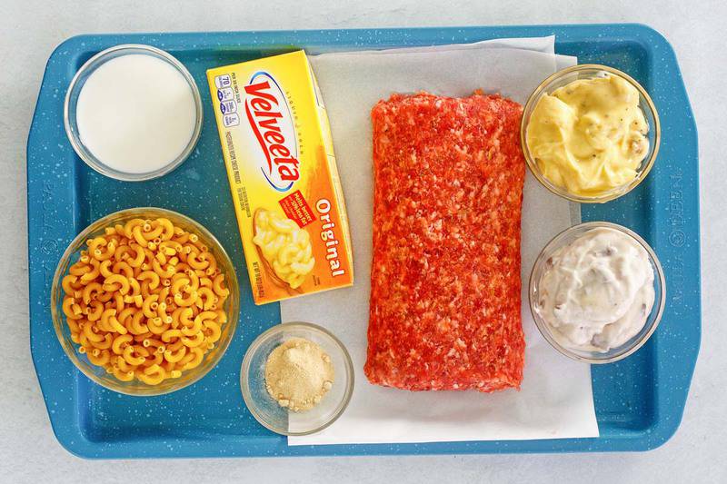sausage mac and cheese casserole ingredients on a tray.